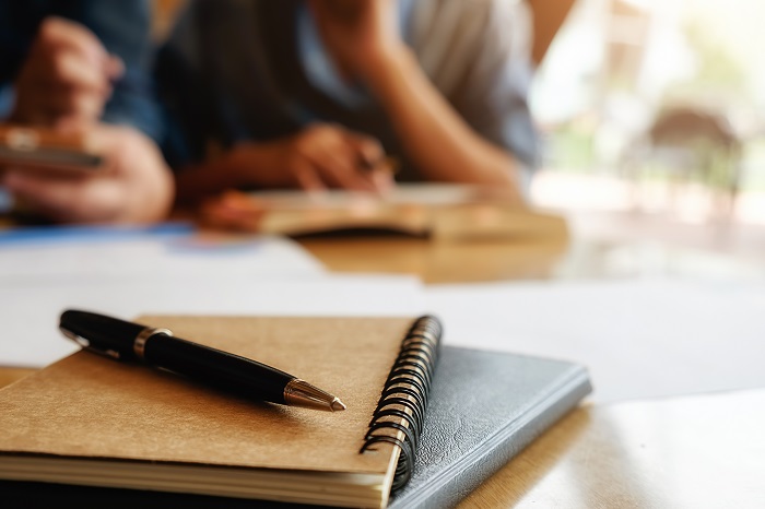 Foto de caderno e caneta sobre uma mesa