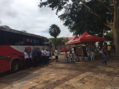 Pessoas de pé na frente do ônibus de Procon Itinerante