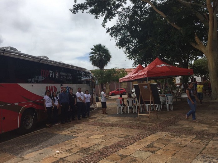 Pessoas de pé na frente do ônibus de Procon Itinerante