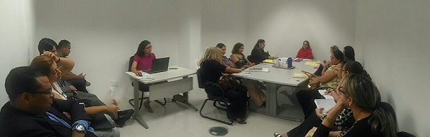 Pessoas sentadas em volta de uma mesa