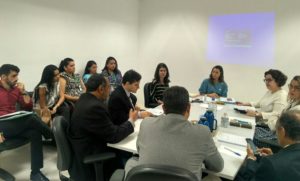 Pessoas sentadas em volta de uma mesa