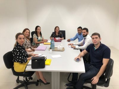 Pessoas sentadas em volta de uma mesa durante audiência