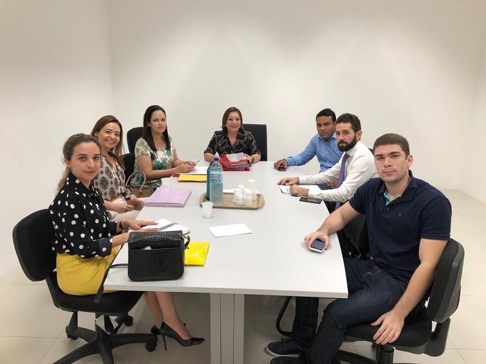 Pessoas sentadas em volta de uma mesa durante audiência