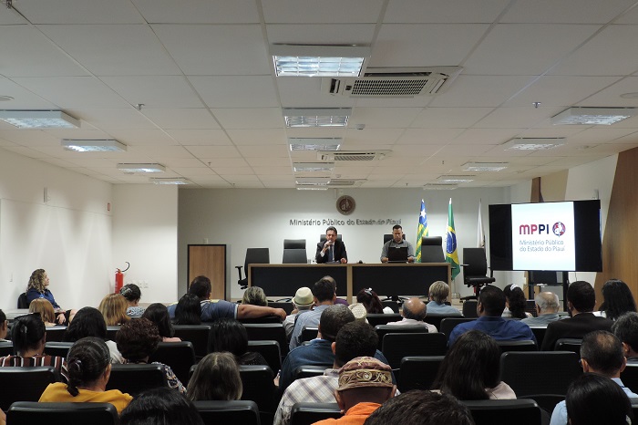 Pessoas sentadas em auditório 
