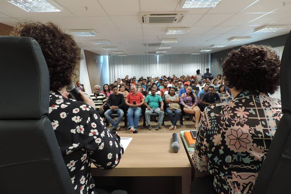 Pessoas sentadas em auditório 