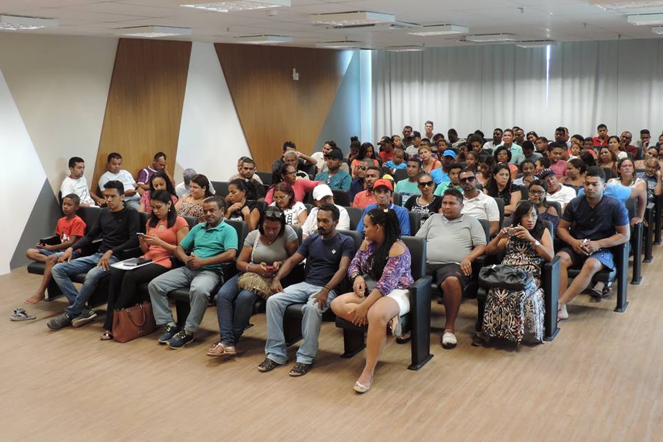 Pessoas sentadas em auditório 