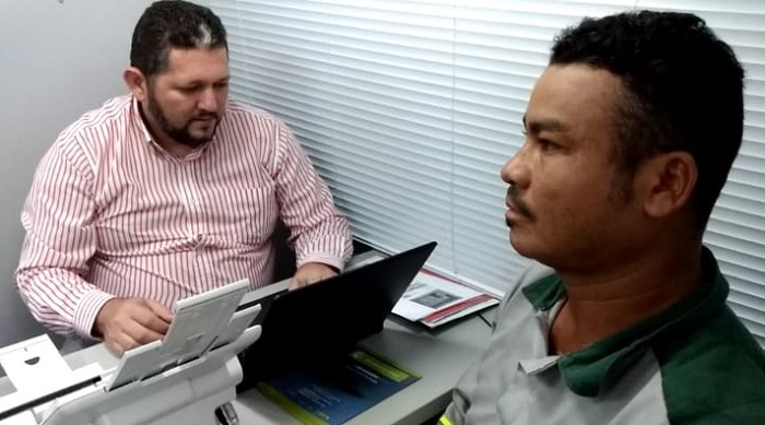 Pessoas sentadas em volta de uma mesa conversando 