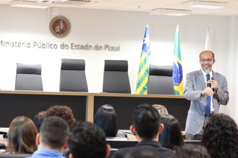 Homem de pé falando com o público sentado que o observa