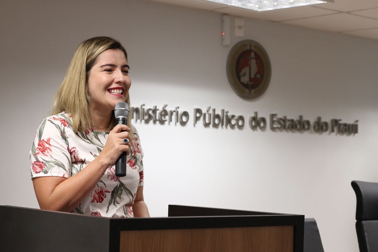 Mulher de pé com microfone nas mãos