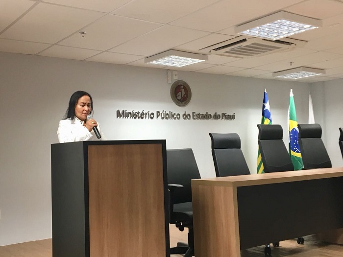 Mulher de pé com microfone nas mãos