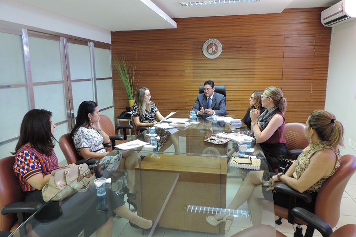 Pessoas sentadas em volta de uma mesa