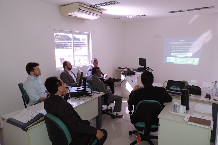 Pessoas sentadas assistindo uma apresentação em slides 