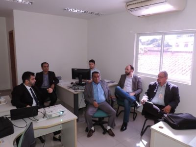 Pessoas sentadas assistindo uma apresentação em slides