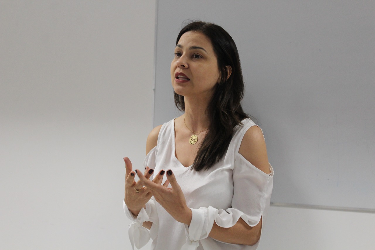 Mulher de pé falando e gesticulando 