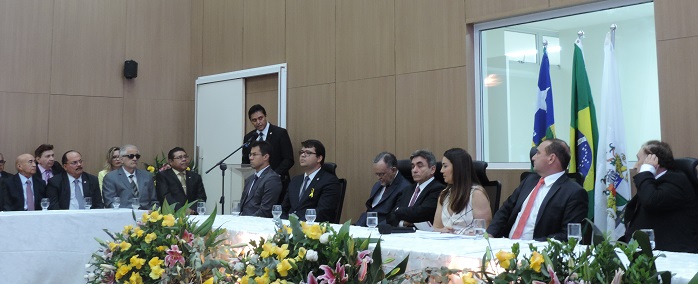 PGJ fala ao microfone diante de mesa de honra