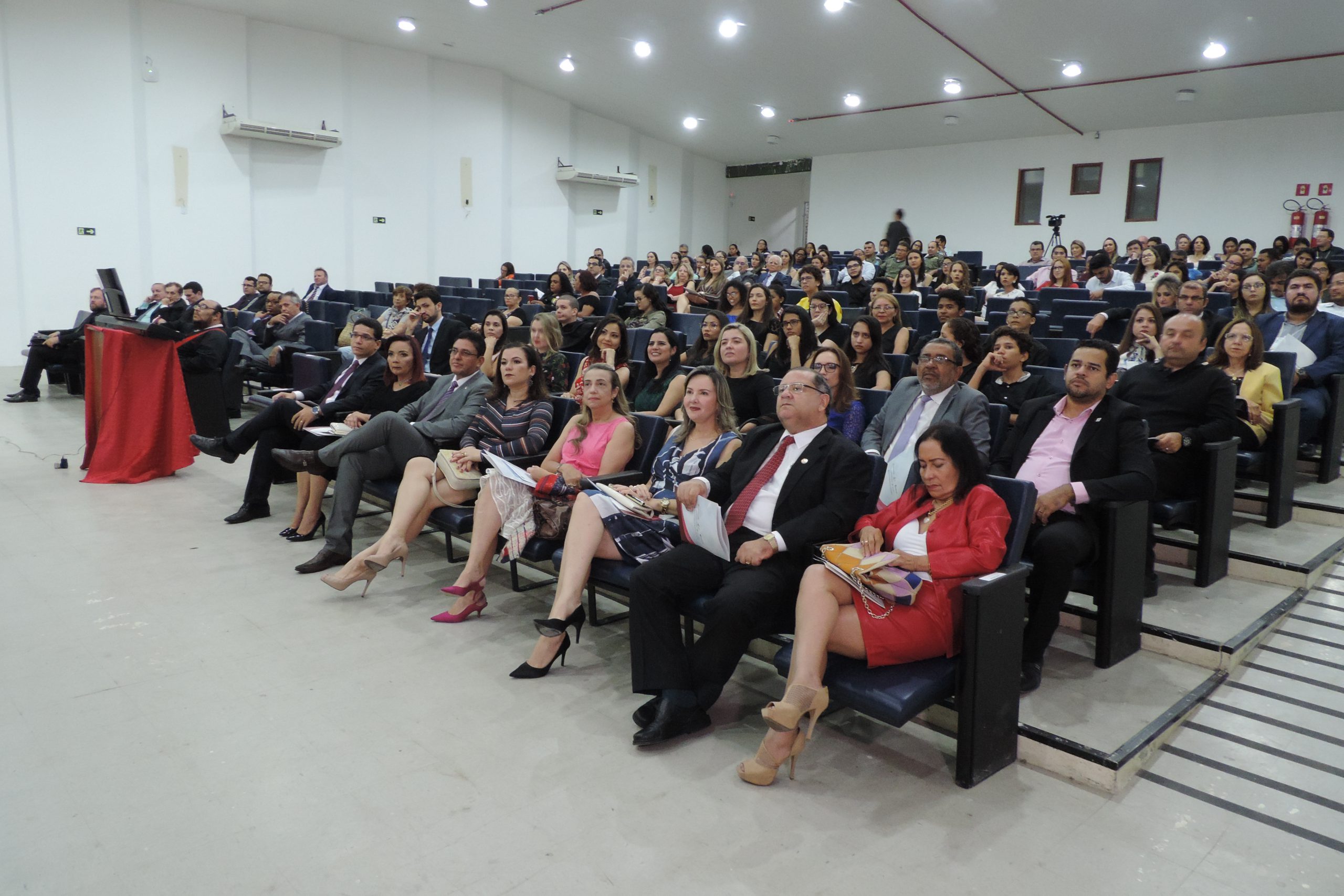 Pessoas sentadas em auditório 