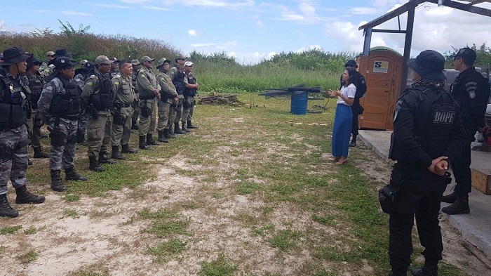Mulher de pé falando com policiais 