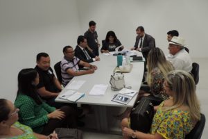 Pessoas sentadas em volta de uma mesa