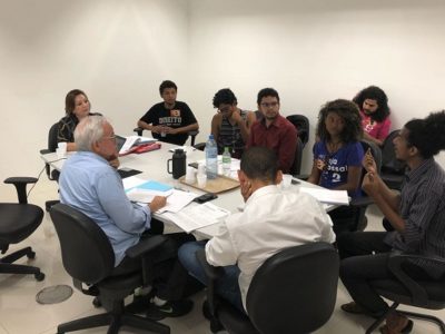 Pessoas sentadas em volta de uma mesa