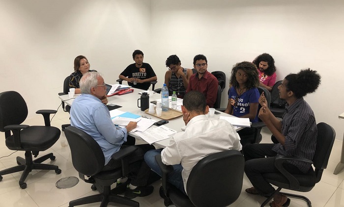 Pessoas sentadas em volta de uma mesa