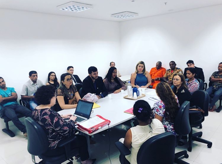 Pessoas sentadas em sala durante reunião