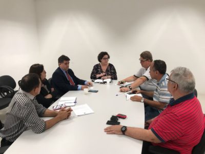 Pessoas sentadas em volta de uma mesa