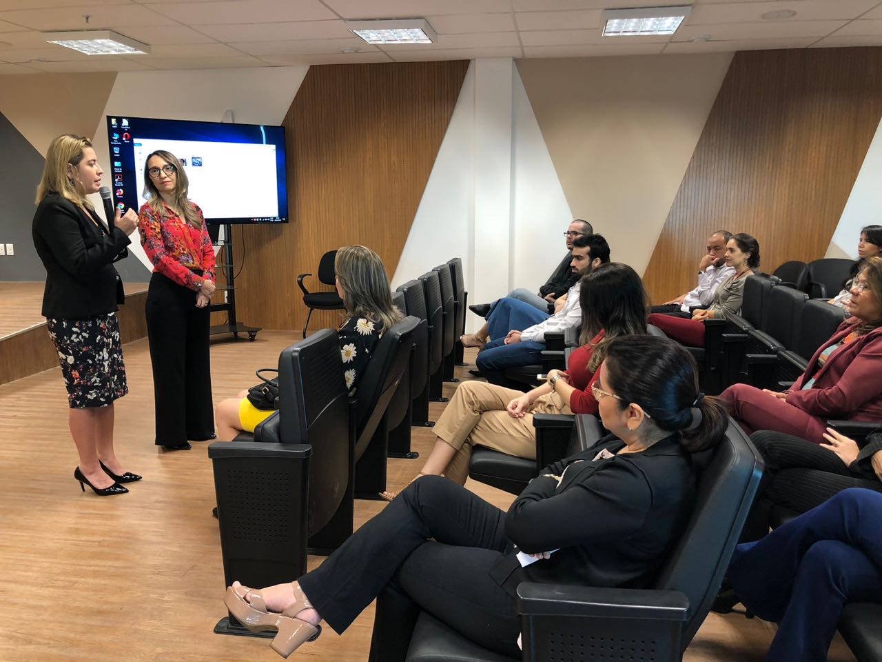 Pessoas sentadas em auditório 