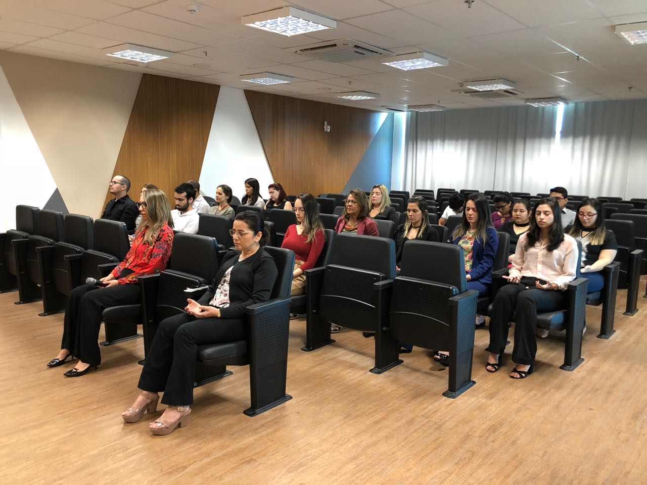 Pessoas sentadas em auditório 