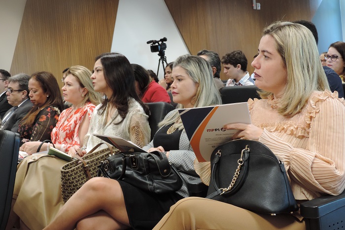 Pessoas sentadas em auditório 