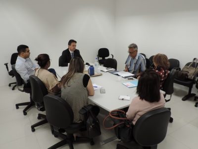Pessoas sentadas em volta de uma mesa conversando entre si
