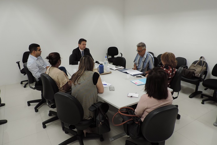 Pessoas sentadas em volta de uma mesa conversando entre si