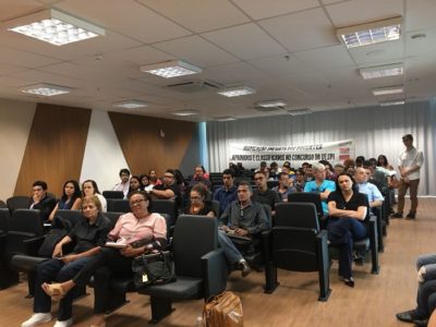 PESSOAS SENTADAS EM AUDITORIO