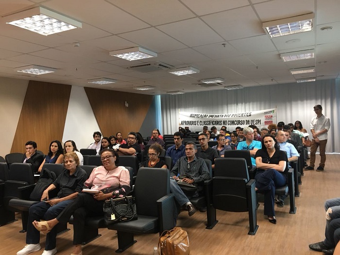 PESSOAS SENTADAS EM AUDITORIO