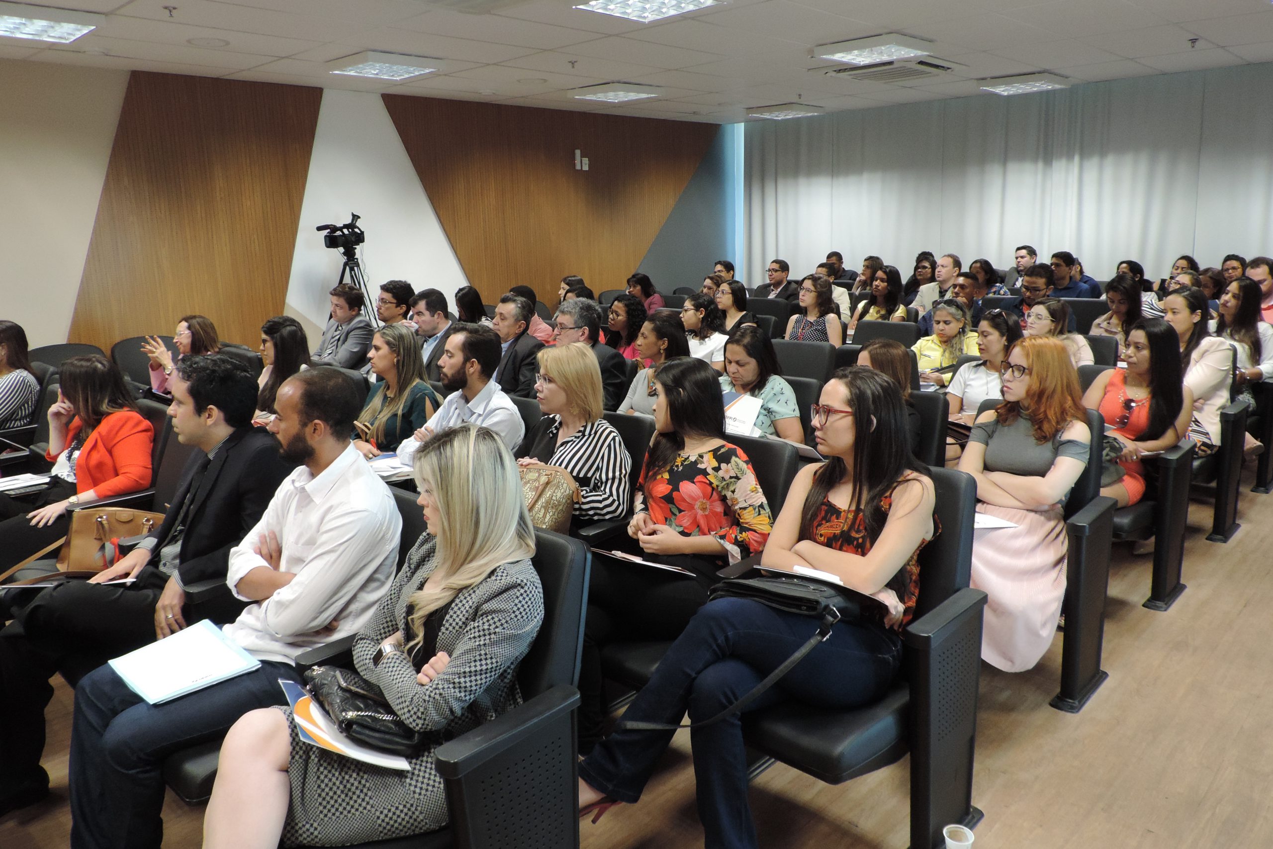 Pessoas sentadas em auditório 
