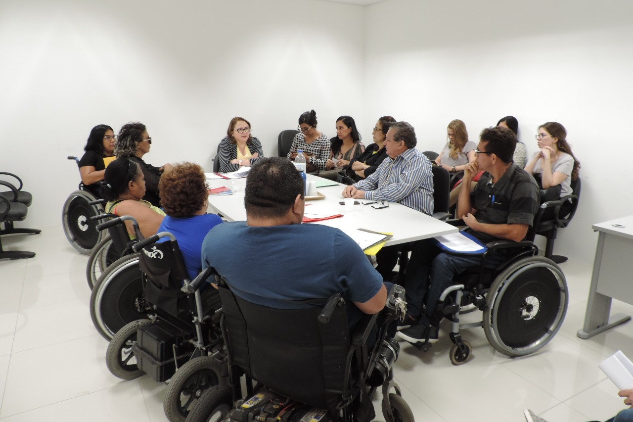 Pessoas sentadas em volta de uma mesa 