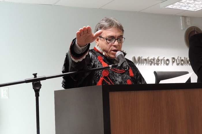 Homem de pé com a mão estendida falando