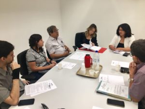 Pessoas sentadas em volta de uma mesa