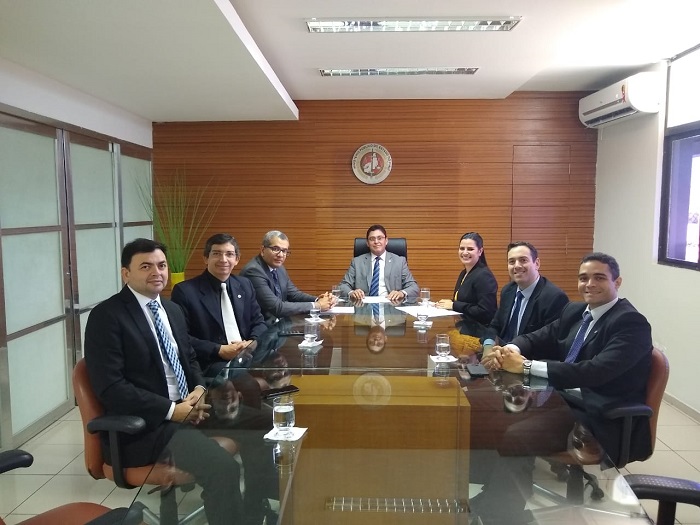 Pessoas sentadas em volta de uma mesa 
