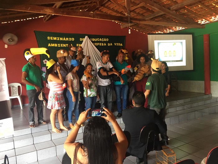 Pessoas de pé com chapéis com representação de animais. 
