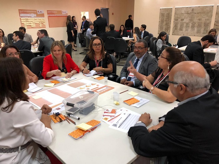 Pessoas sentadas em volta de uma mesa conversando 