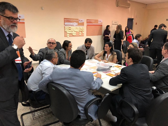 Pessoas sentadas em volta de uma mesa conversando 