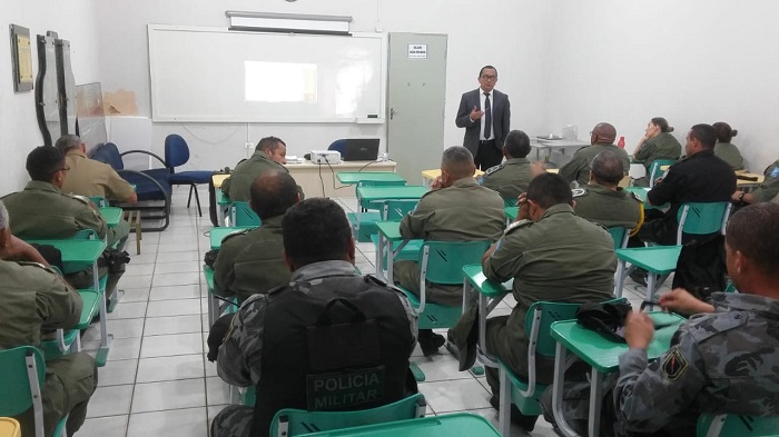 Pessoas sentadas em sala de aula com homem que está de pé 