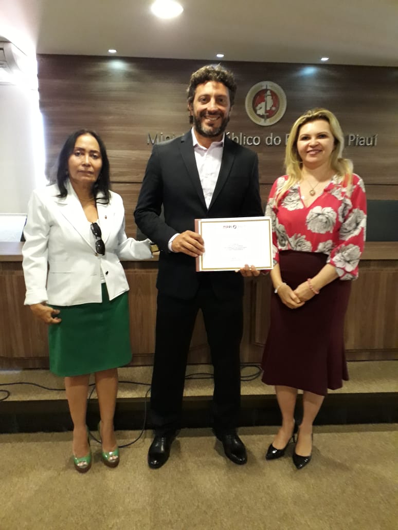 Três pessoas de pé sorrindo 