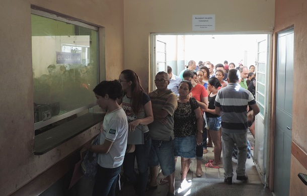 Pessoas de pé esperando atendimento 