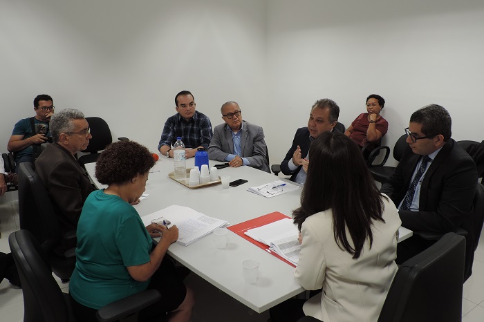 Pessoas sentadas em volta de uma mesa 