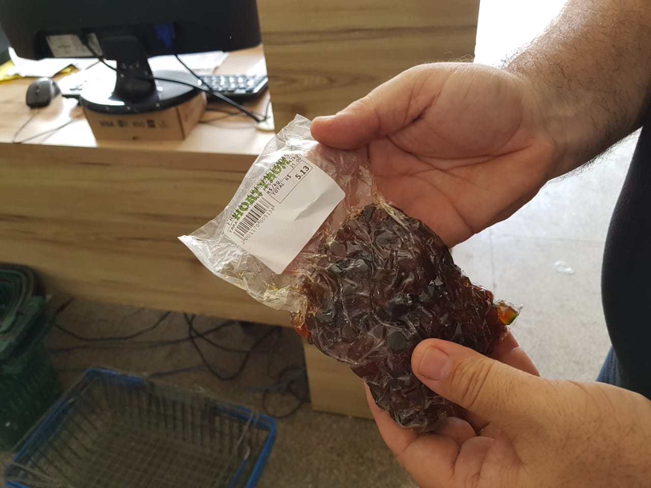 Pessoas segurando um pacote com carne dentro 