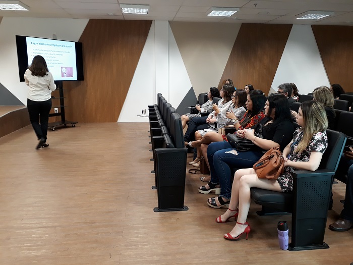 Pessoas sentadas em uma plateia assistindo palestra 