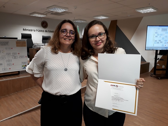 Duas mulheres de pé sorrindo para fotografia 
