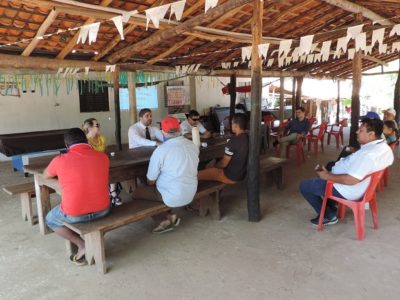 Pessoas sentadas em uma área coberta assistindo a uma palestra