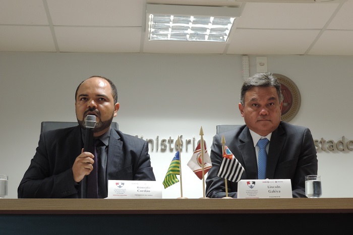 Dois homens sentado atrás de uma mesa 